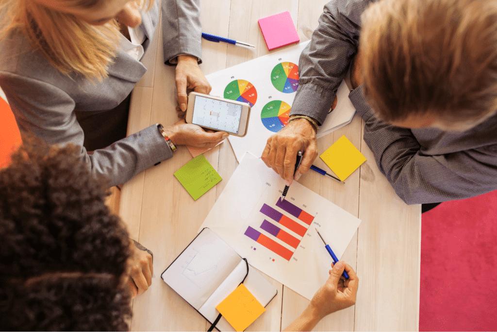 Team collaboration on data analysis and strategic planning with charts and notes.