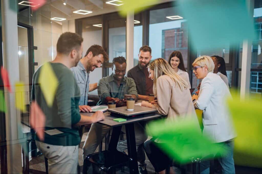 Team collaborating effectively in a modern workspace with sticky notes and brainstorming tools.