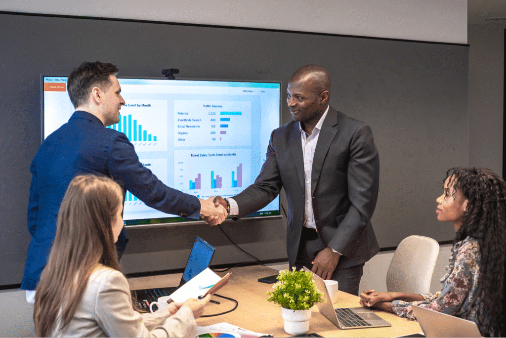 Business professionals finalize a partnership agreement during a productive meeting about predictable software delivery.
