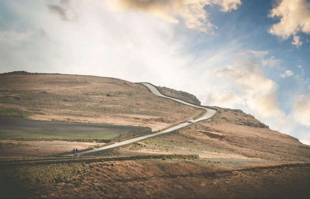 Winding hillside road beneath a stunning sky, perfect for scenic drives and outdoor adventures.