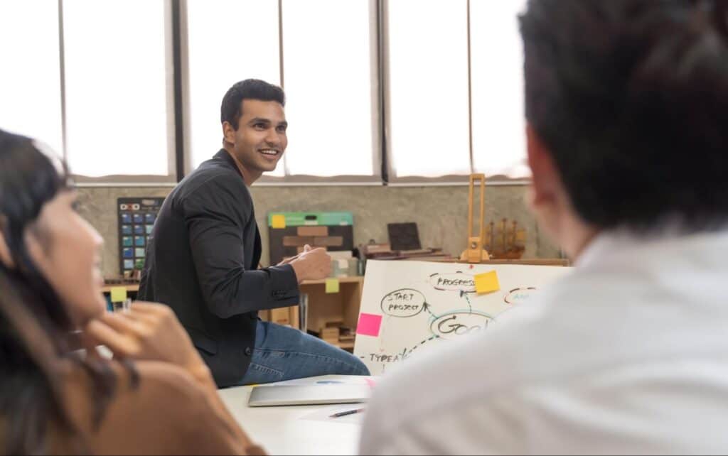 Team members engaged in brainstorming and collaborative discussion in a creative workspace.