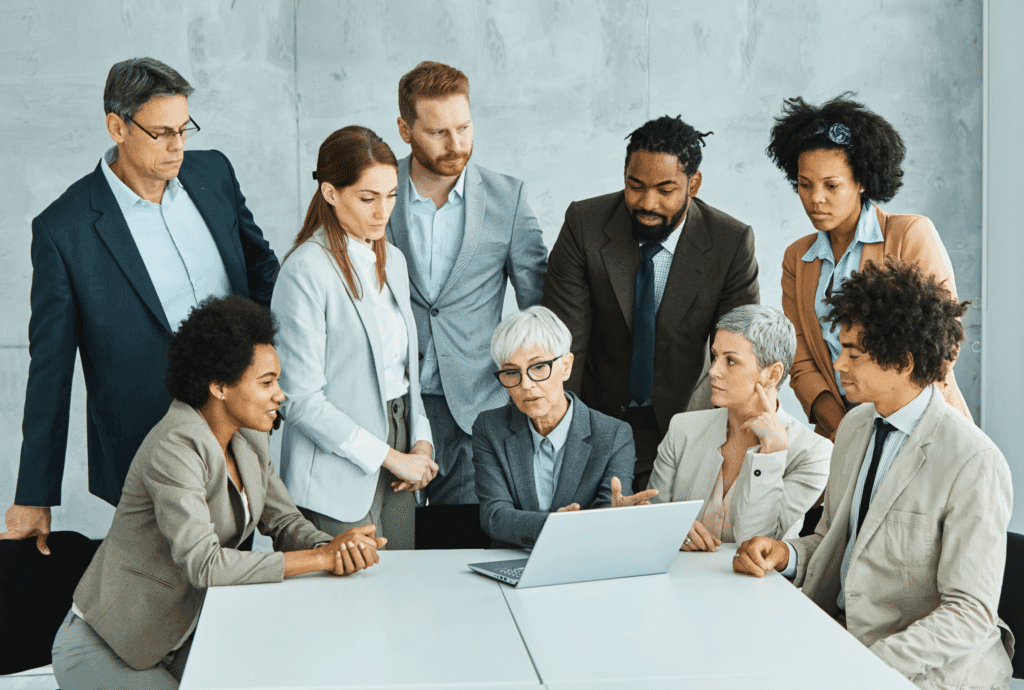 Team meeting focused on collaboration and discussion around a laptop.