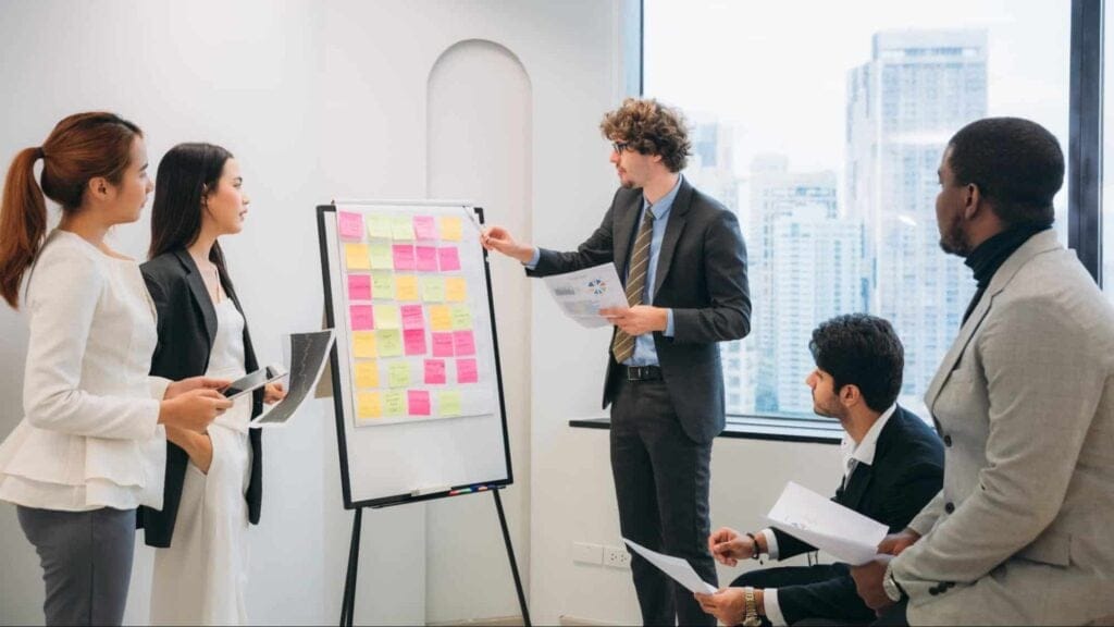 Team collaborating in a business meeting with sticky notes and presentations.