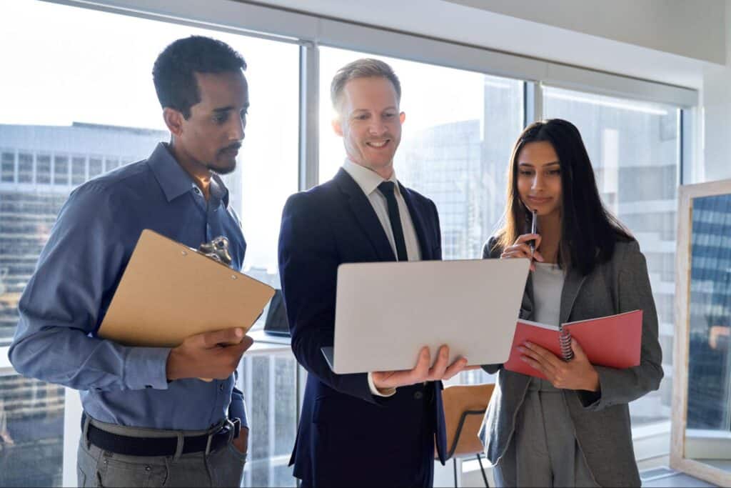 Business team collaborating on a laptop receiving Agile Transformation Consulting services.