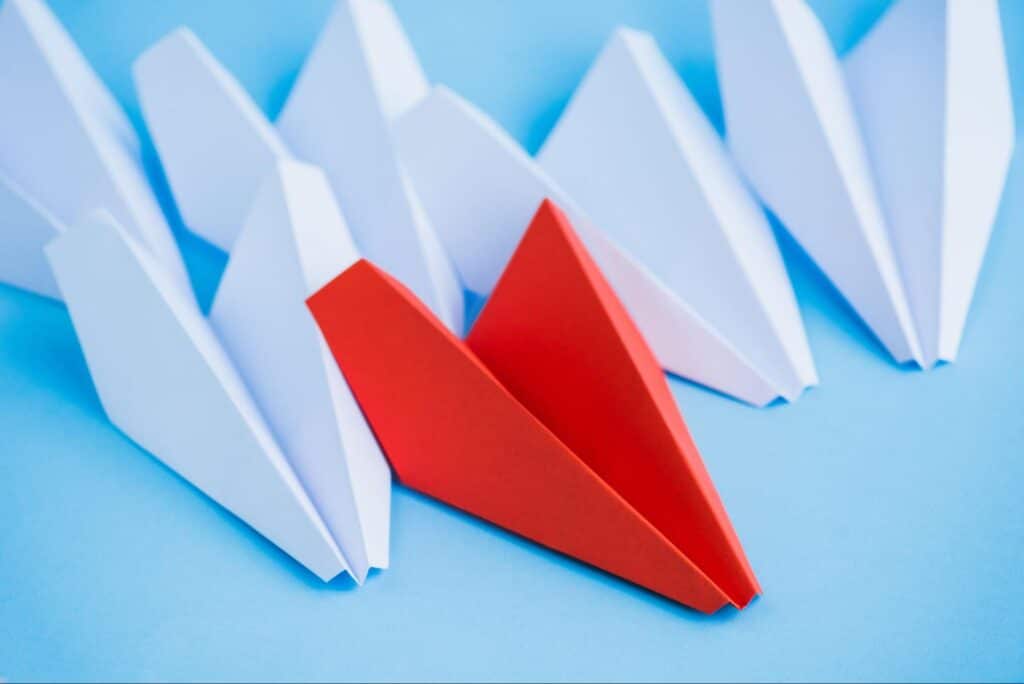 Colorful paper airplanes on a blue background, showcasing creativity and playfulness.