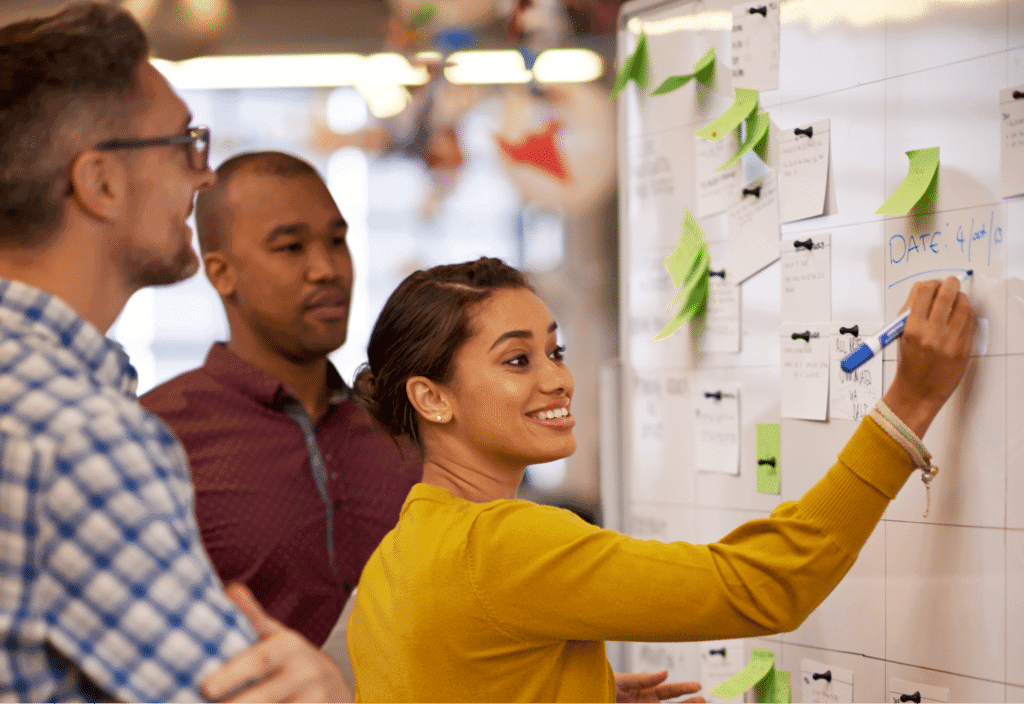 Team members brainstorming ideas on a whiteboard during a collaborative session.
