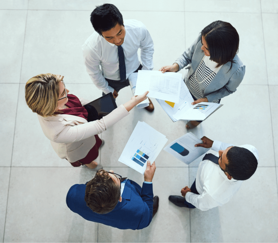 Team members collaborating and sharing documents during a productive meeting.