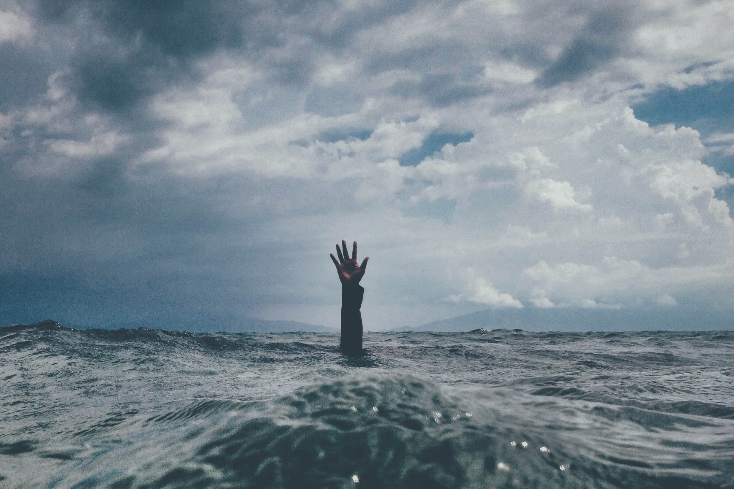 Person drowning in a sea of uncertainty and stress caused by an unsafe team environment