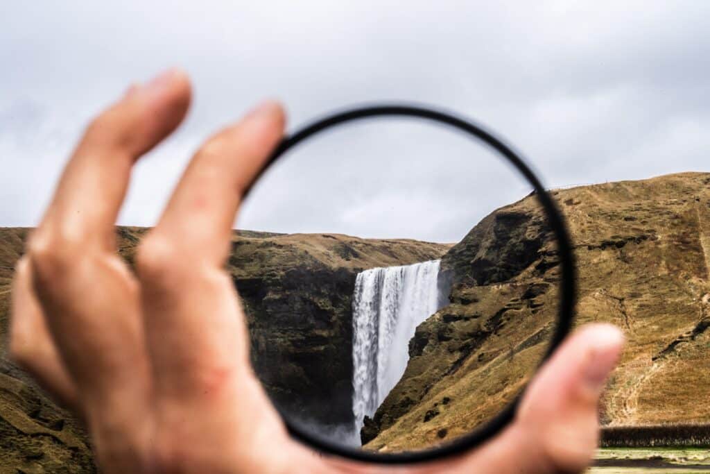 A clear view of a waterfall through a magnifying glass to represent the clarity gained after exploring various business agility models.