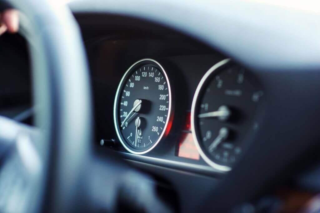 Car dashboard close-up showing speedometer and fuel gauge.