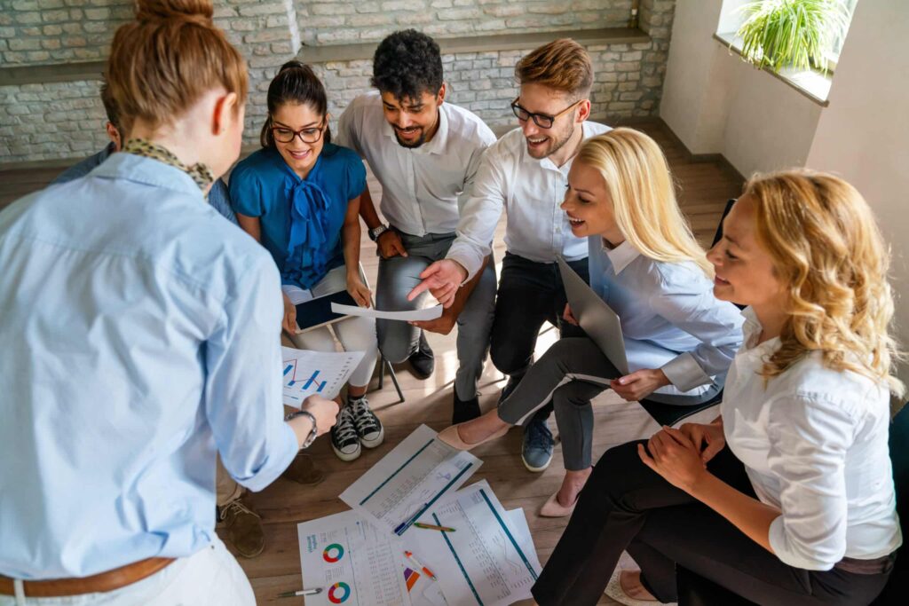 Diverse team collaborates on sprint planning and financial reports in a modern workspace.