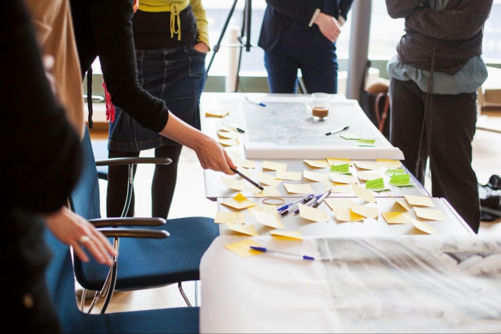 Team collaborating using sticky notes during a brainstorming session at a workspace.