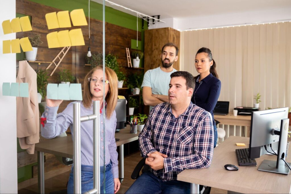 Team brainstorming session with sticky notes and collaboration in a modern office.