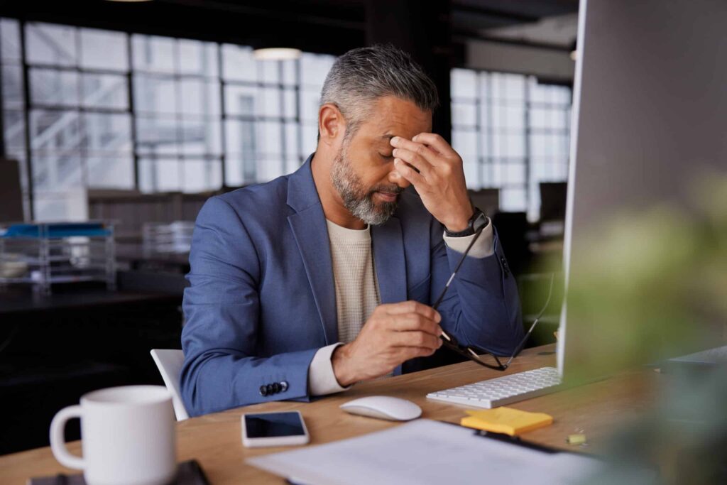 Frustrated professional at work struggling with stress and concentration in a modern office.