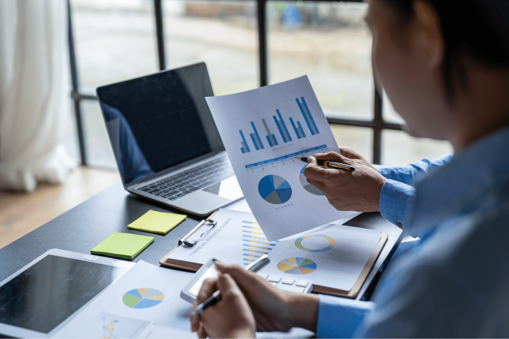 Analyzing business reports with graphs and charts in an office setting.