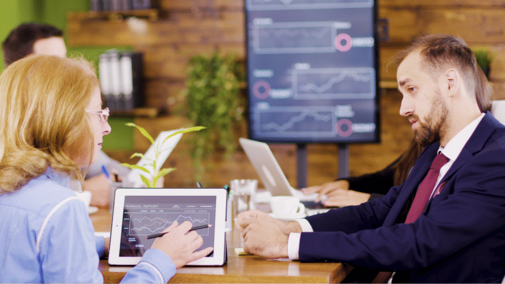 Colleagues discussing data analyses in a business meeting with presentations.