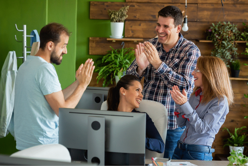 Team members celebrate appreciation in a vibrant office setting.
