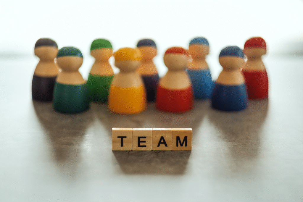 Colorful wooden figures representing a diverse and collaborative team.