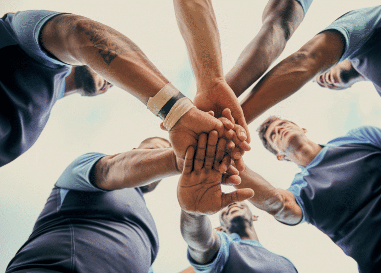 Hands united in teamwork, showcasing collaboration and unity among teammates.