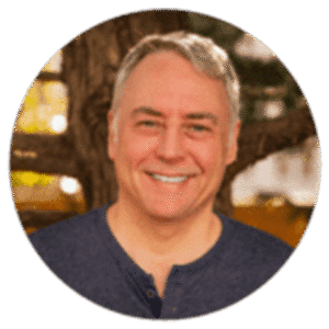 Smiling man outdoors, showcasing a warm expression and relaxed atmosphere.
