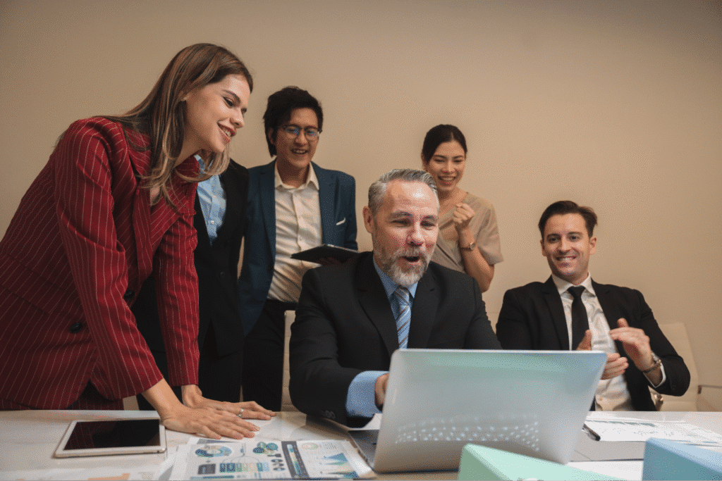 Team brainstorming and collaborating over a laptop in a modern office setting.