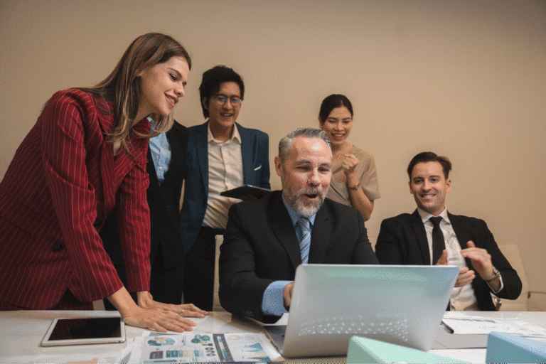 Team brainstorming and collaborating over a laptop in a modern office setting.