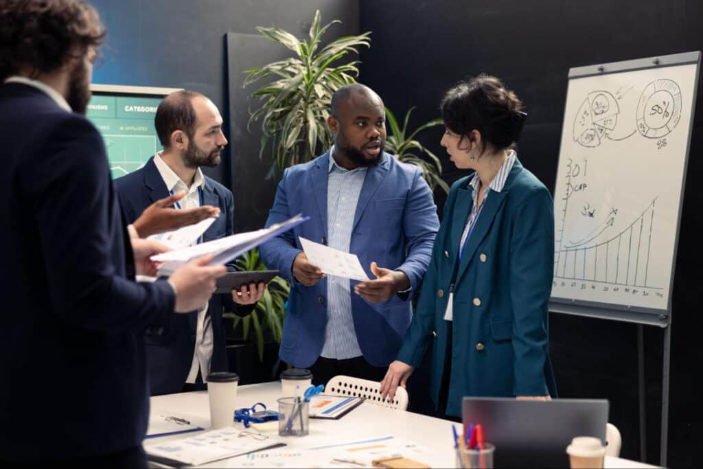 Business team collaborating in a modern office setting with charts and documents.