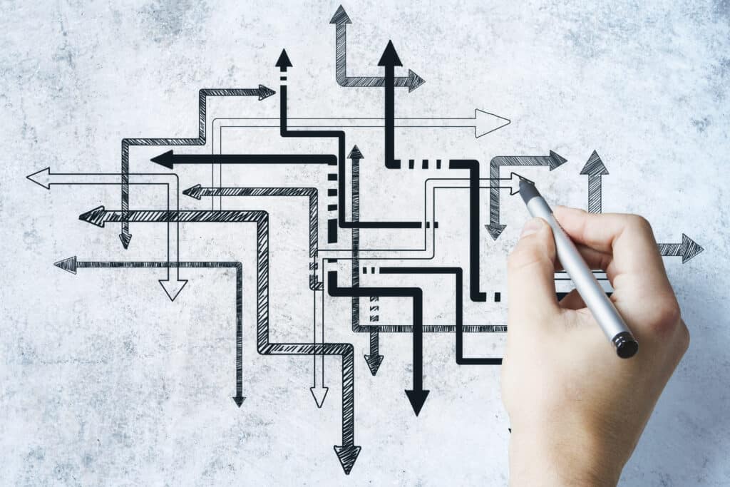 Hand-drawn arrows connect in various directions on a concrete background.