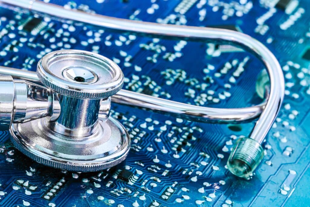 Stethoscope resting on a blue circuit board, symbolizing medical technology integration.
